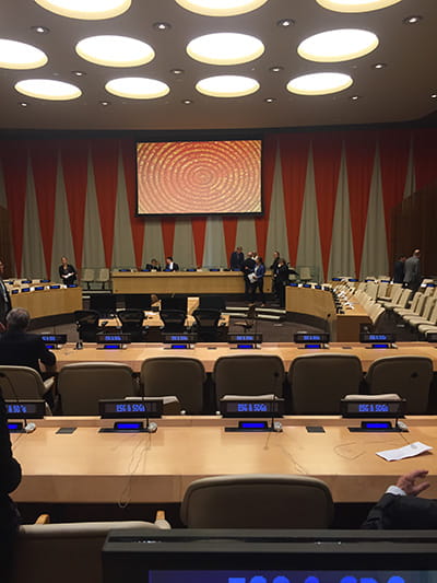 Conference room with two people at the front of the room talking.